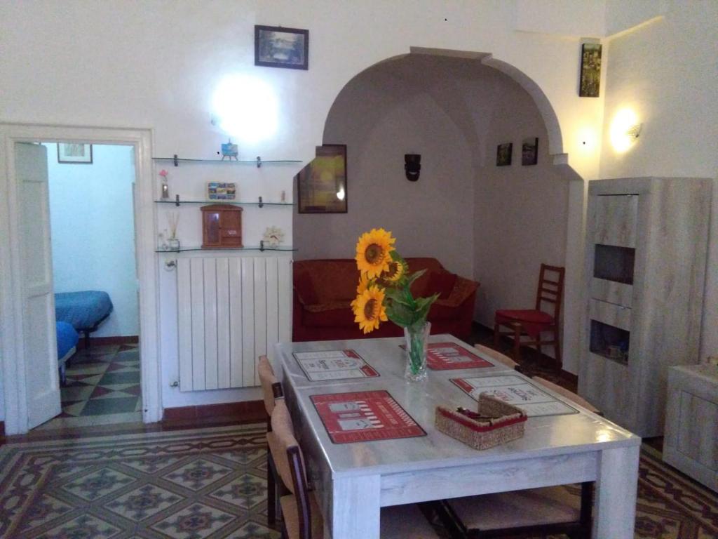 a living room with a table and a vase with a sunflower at House 1909 in Ostuni