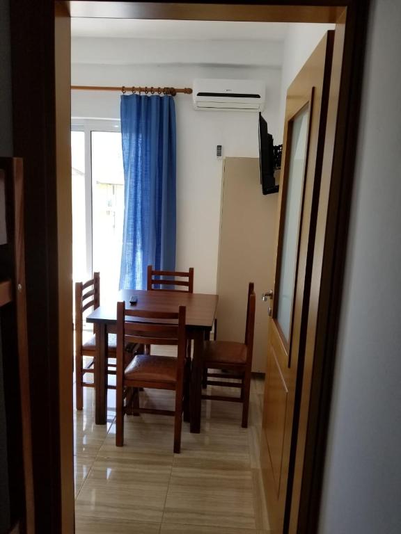 a dining room with a table and chairs and a blue curtain at Romantika in Shëngjin