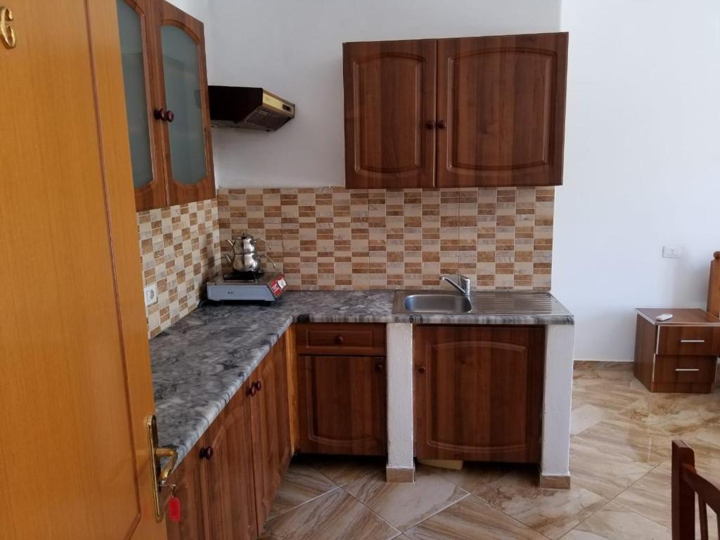 a kitchen with wooden cabinets and a sink at Romantika in Shëngjin