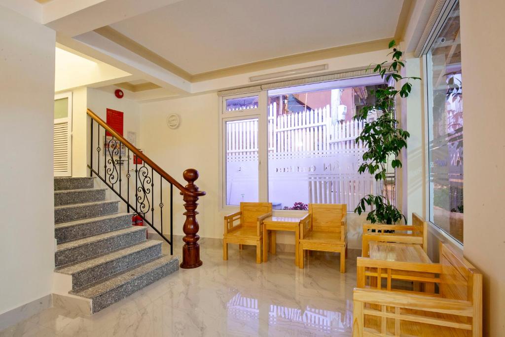 a living room with a table and chairs and a staircase at THIEN AN GUEST HOUSE in Da Lat