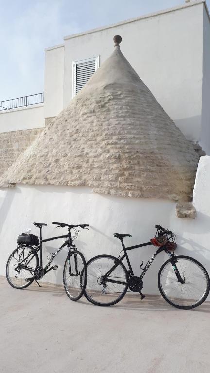 twee fietsen geparkeerd voor een gebouw bij Dimora Rossa in Cisternino