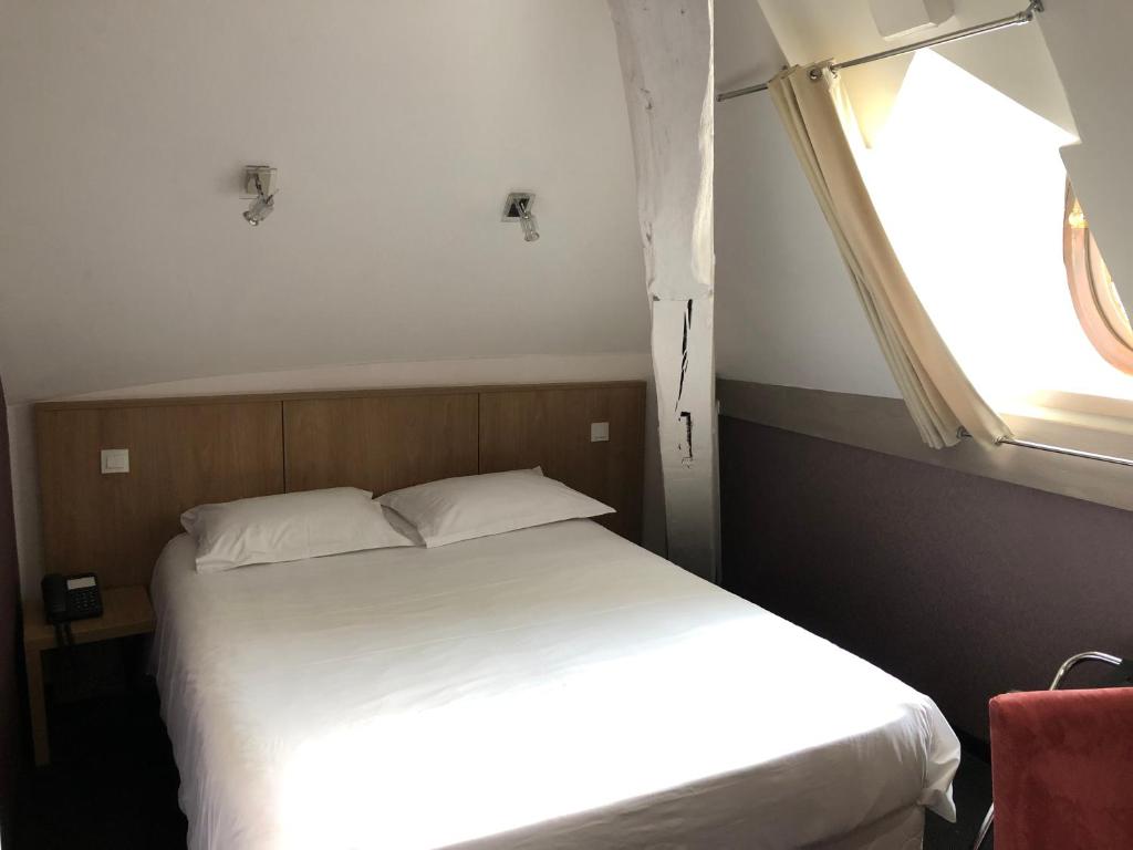 Postel nebo postele na pokoji v ubytování Logis L'Hôtel D'Arc