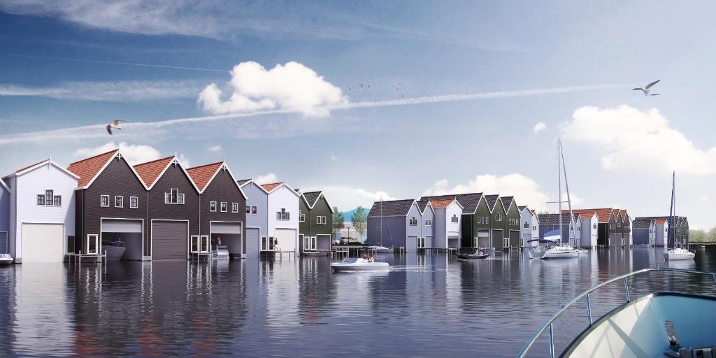 een weergave van huizen in het water met boten bij Huis van Harderwijk in Harderwijk