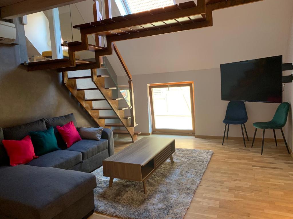 a living room with a couch and a tv at Appart LE COUCOU in Saint-Hippolyte