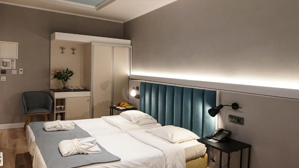 a hotel room with two beds and a telephone at Athens Cypria Hotel in Athens