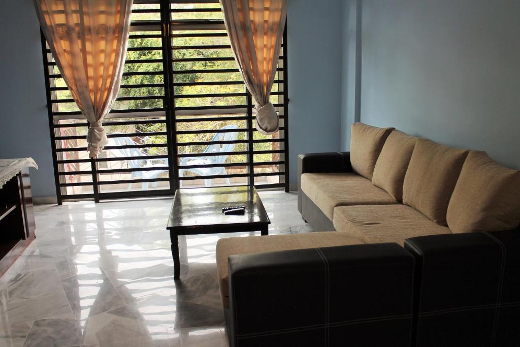 a living room with a couch and a table at Teluk Kemang Homestay - Laguna Resort in Port Dickson