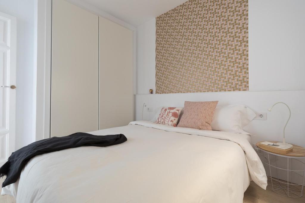 A bed or beds in a room at Casa Cosi - Eixample 3