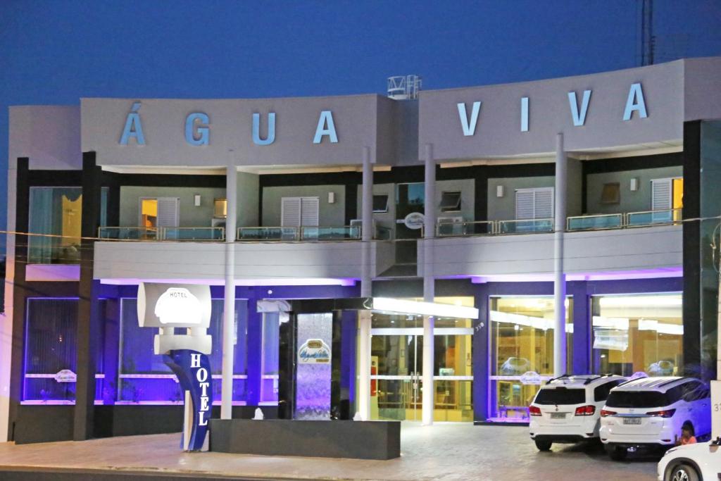 a building with cars parked in front of it at Água Viva Hotel in Olímpia