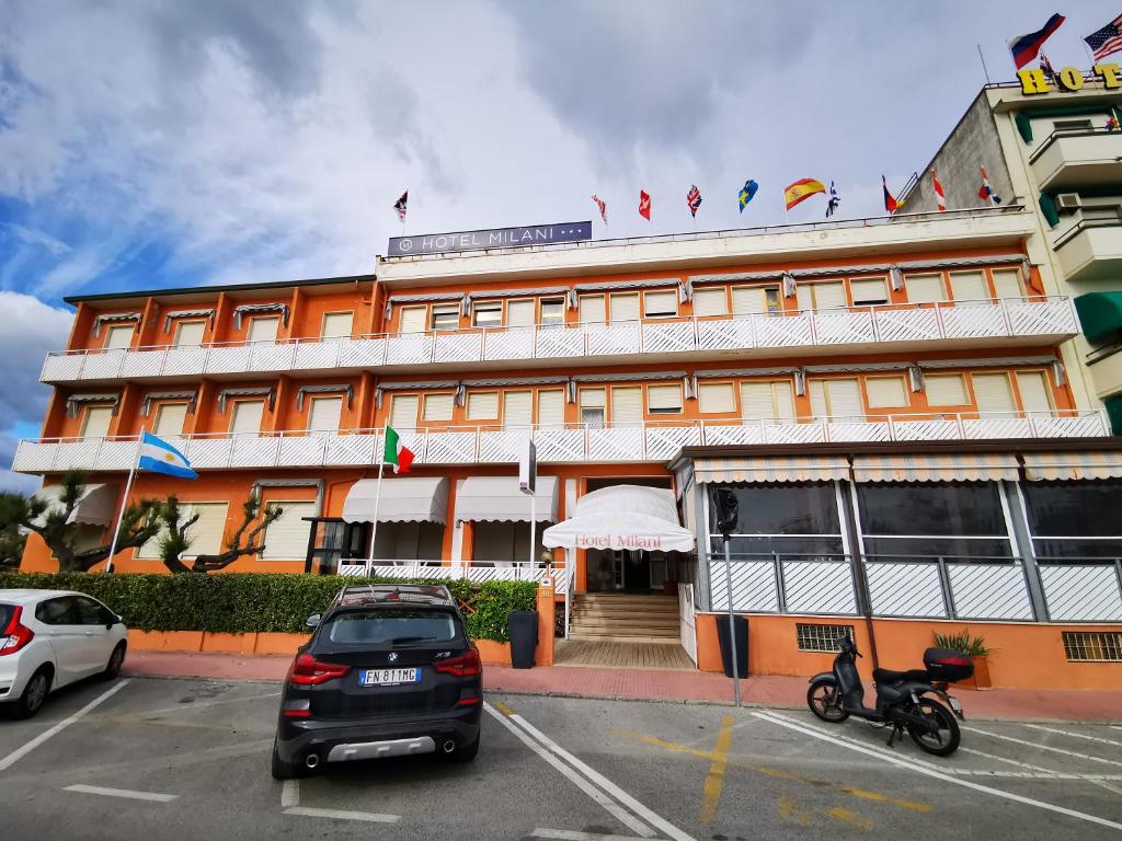 a car parked in a parking lot in front of a building at Hotel Milani in Lido di Camaiore