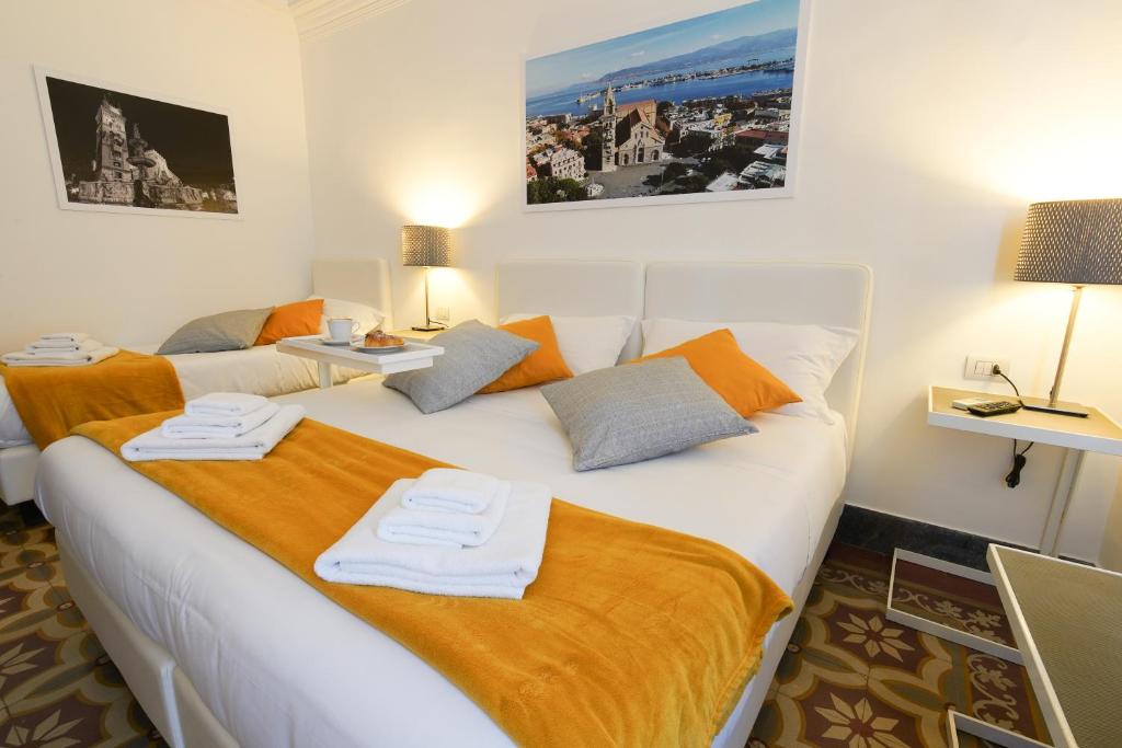 1 dormitorio con 1 cama blanca grande con sábanas de color naranja en Le Stanze di Piazza Cairoli, en Messina