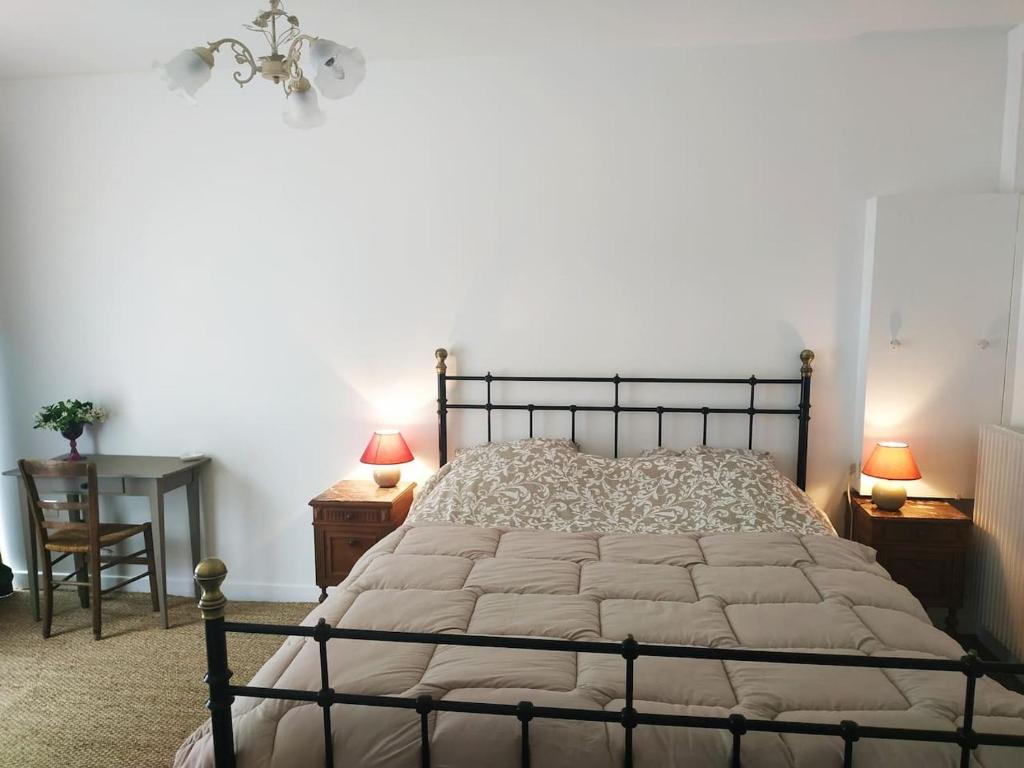 a bedroom with a bed and two lamps and a chair at Le Voltaire in Souppes-sur-Loing