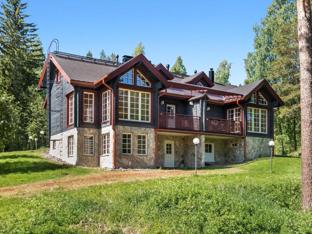 ein großes Haus auf einem Hügel mit Bäumen in der Unterkunft Holiday Home Syvärinkulta b by Interhome in Tahkovuori