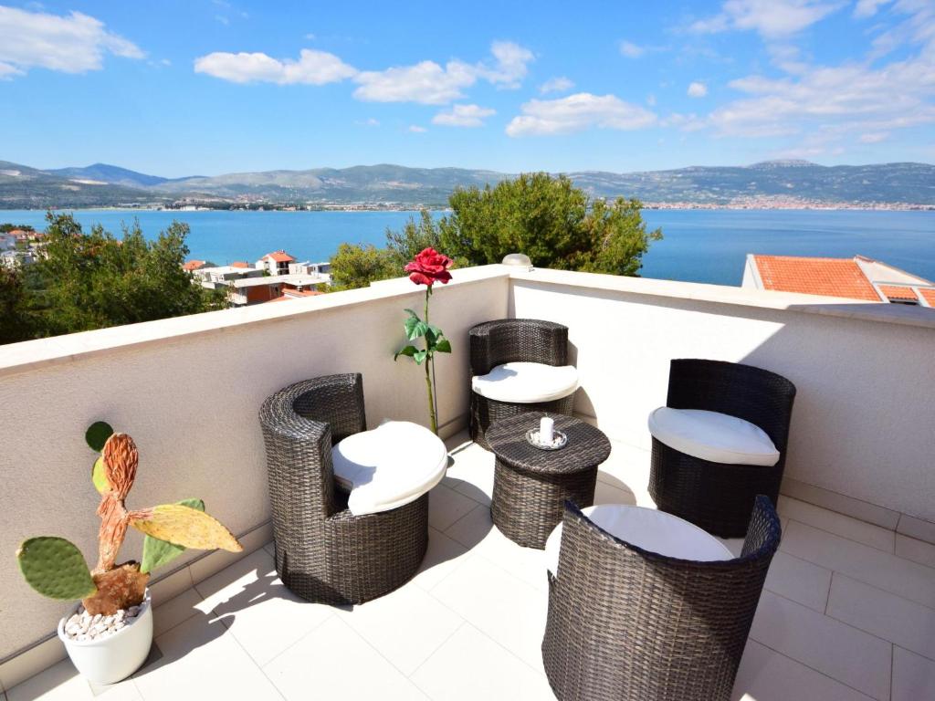 balkon z wiklinowymi stołkami i widokiem na wodę w obiekcie Apartment Anđa-1 by Interhome w Trogirze