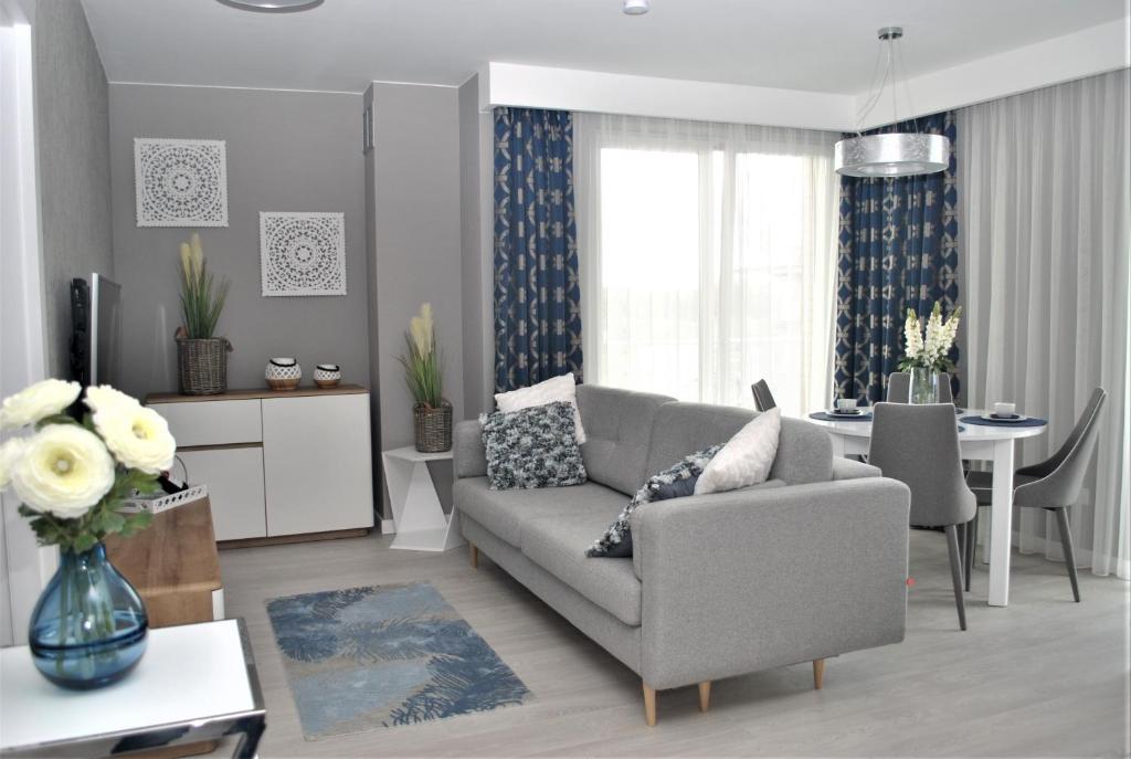 - un salon avec un canapé et une salle à manger dans l'établissement Apartament Mirage Classic, à Rewal