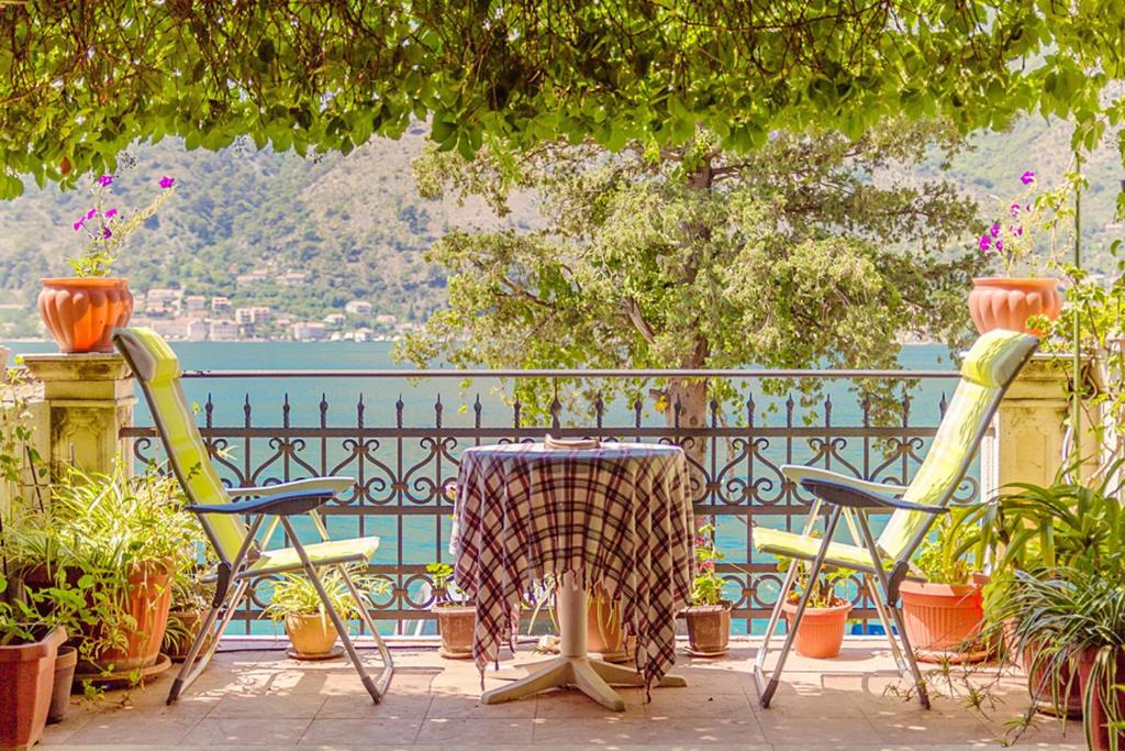 una mesa y sillas en un patio con vistas al agua en Villa Donković en Kotor