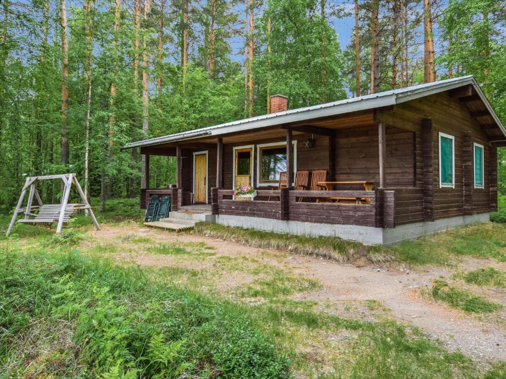 a log cabin in the woods with a porch at Holiday Home Mäntyranta by Interhome in Harjula