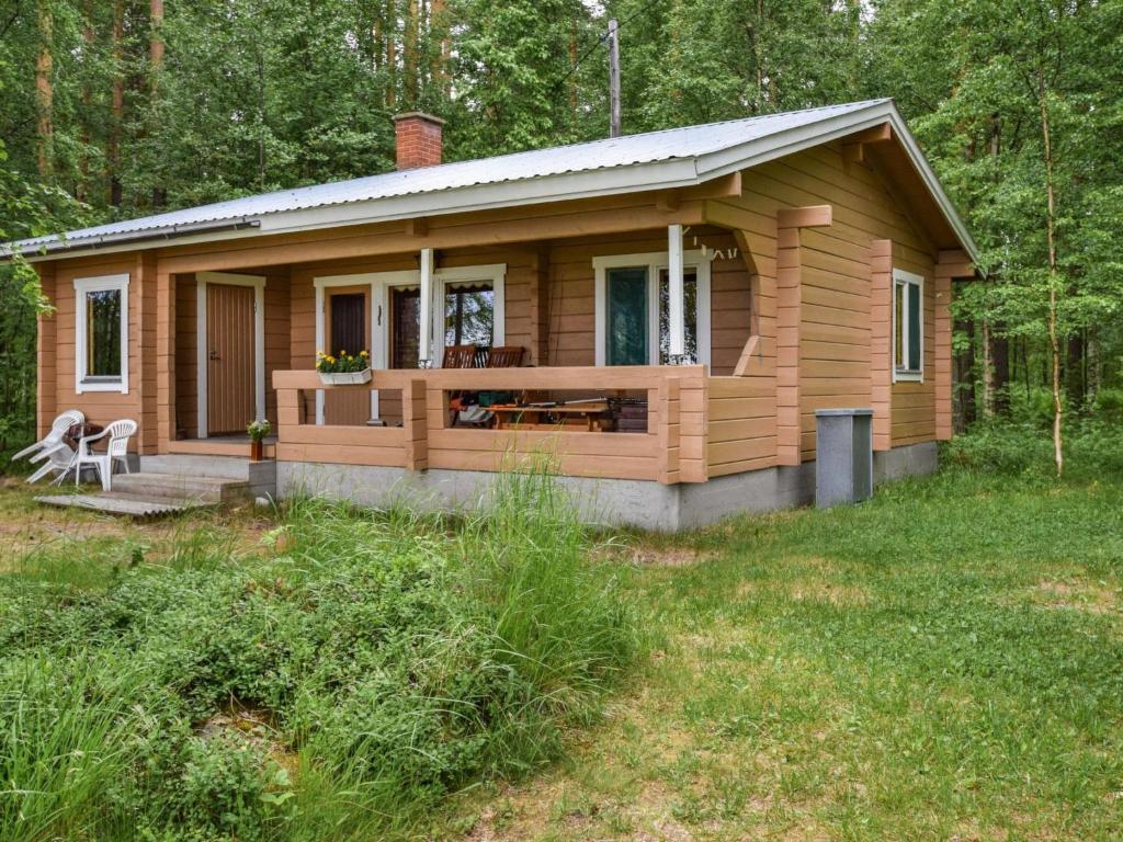 a small cabin in the woods with a deck at Holiday Home Koivuranta by Interhome in Oravi