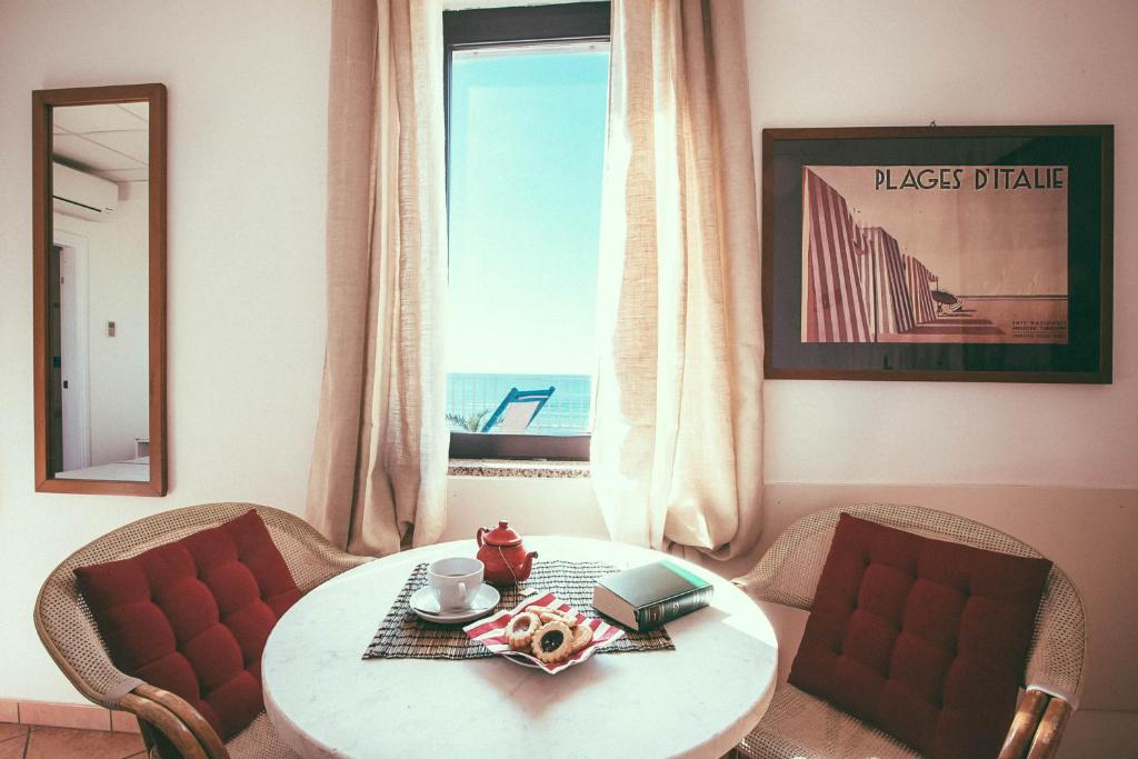 a room with a table and chairs and a window at Hotel Sirenetta in Lido di Ostia