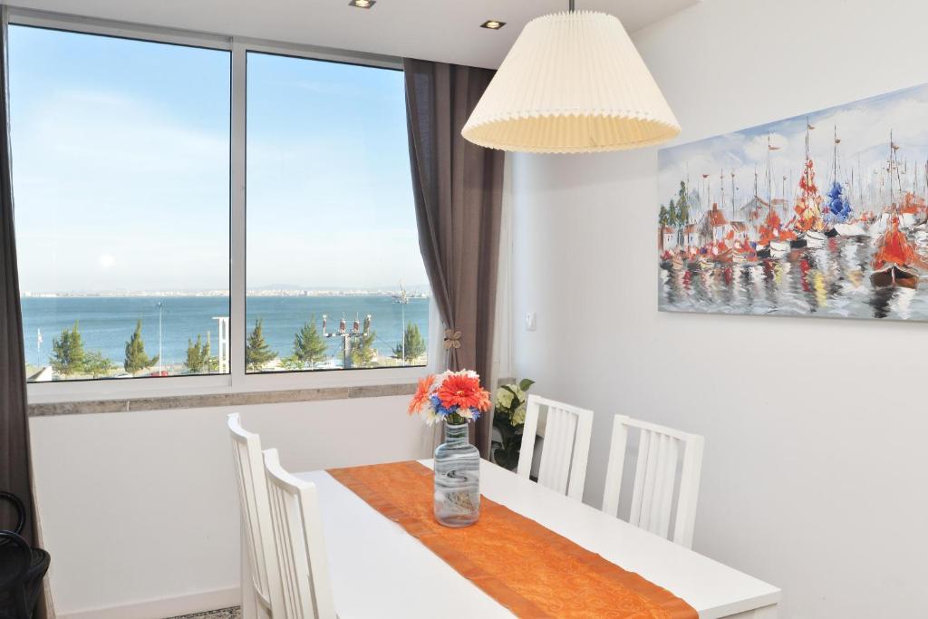 un comedor blanco con mesa y ventana en Tejo Blue & Bright - Checkinhome en Lisboa