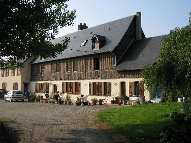 ein großes weißes Gebäude mit schwarzem Dach in der Unterkunft Chambres d'Hôtes Lambert Rouen in Saint-Jean-du-Cardonnay