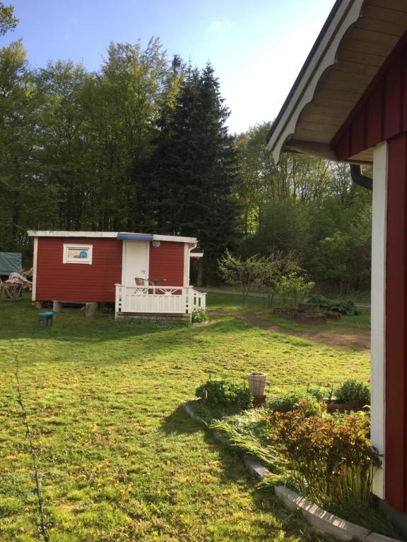 un cobertizo rojo y blanco en un patio en Dövared, en Tvååker