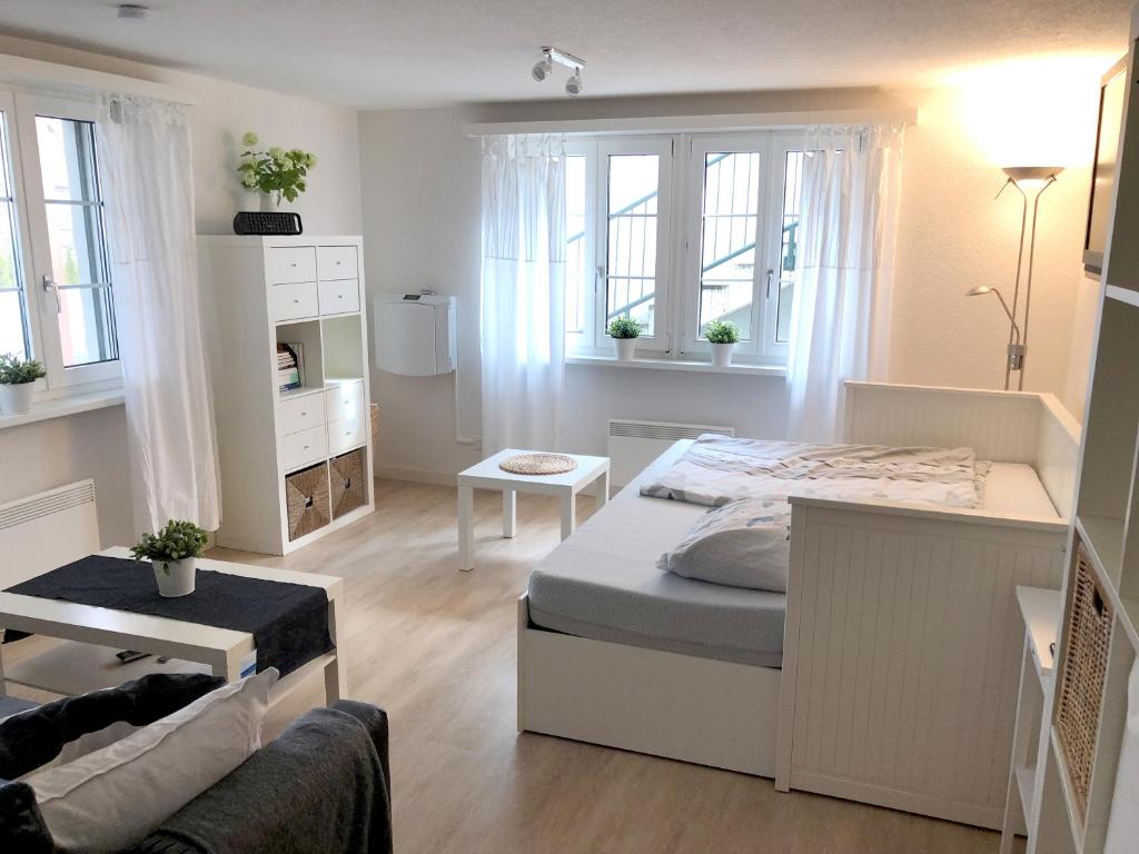 NiedererlinsbachにあるFerienwohnung Erlinsbach SOの白いベッドルーム(ベッド1台、ソファ付)