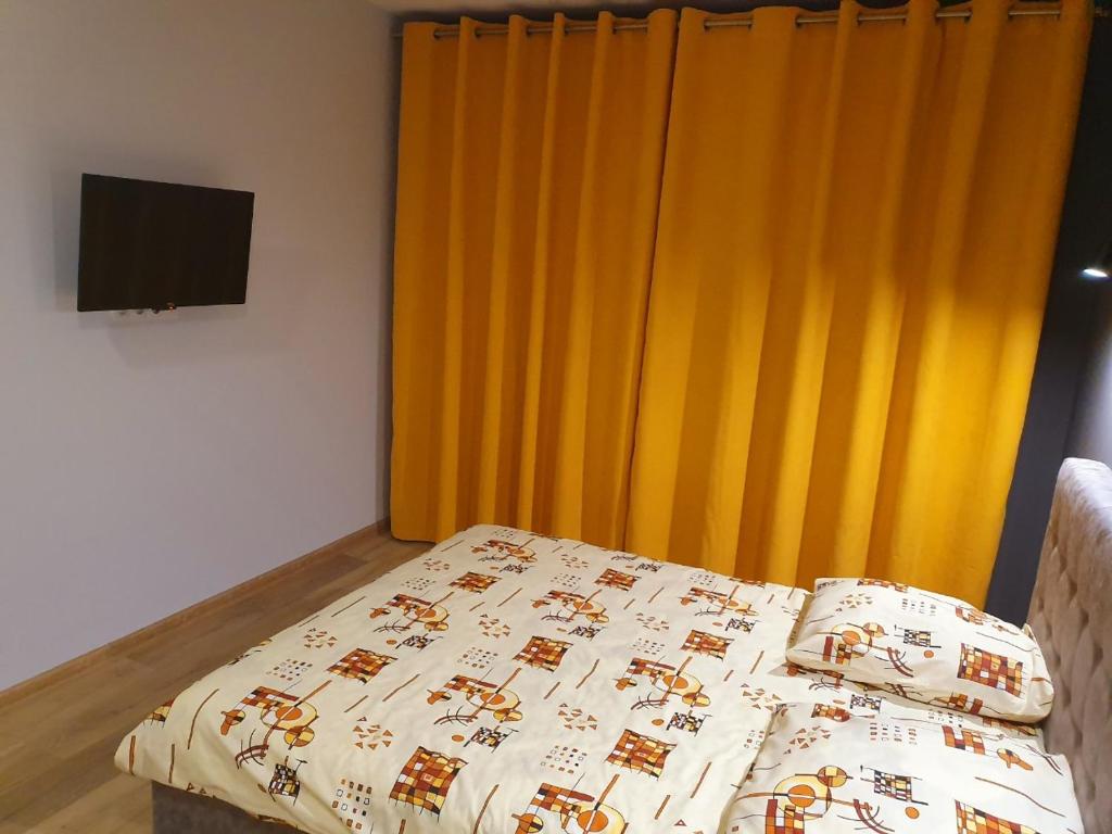 1 cama con edredón y cortina amarilla en VIP apartment in the centre, en Uzhhorod