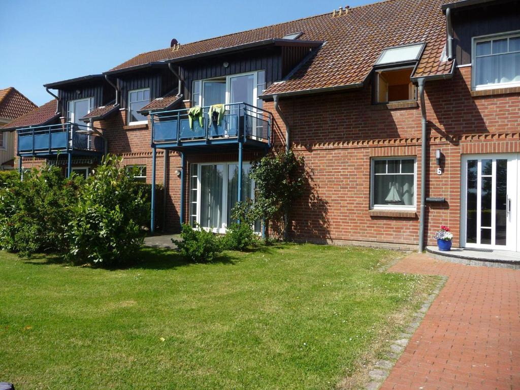 a brick house with a balcony and a yard at GODS06004-FeWo-de-Klipp in Gollendorf