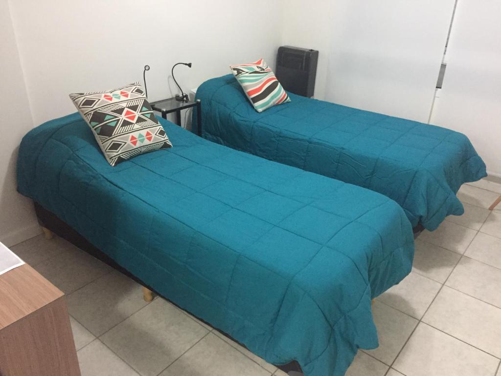 2 camas con colchas azules en una habitación en LAS MARINAS RENT en Bahía Blanca