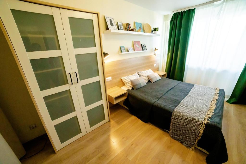 a bedroom with a bed and a sliding glass door at OpenApart - Семейное гнездо in Izhevsk