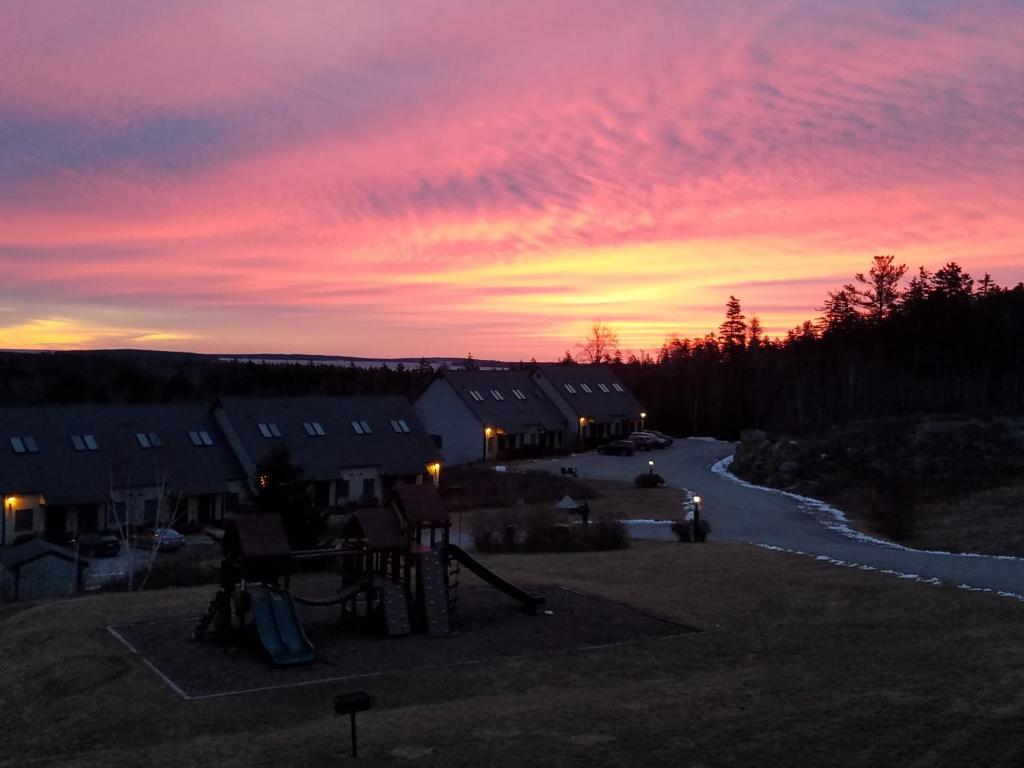 einen Sonnenuntergang über einer Gruppe von Häusern und einer Straße in der Unterkunft Harbor Ridge in Southwest Harbor