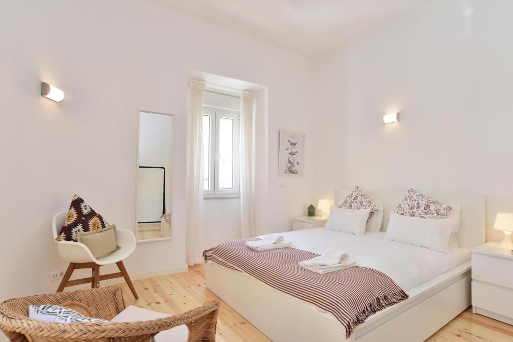 1 dormitorio blanco con 1 cama y 1 silla en Amazing Grace - Checkinhome, en Lisboa