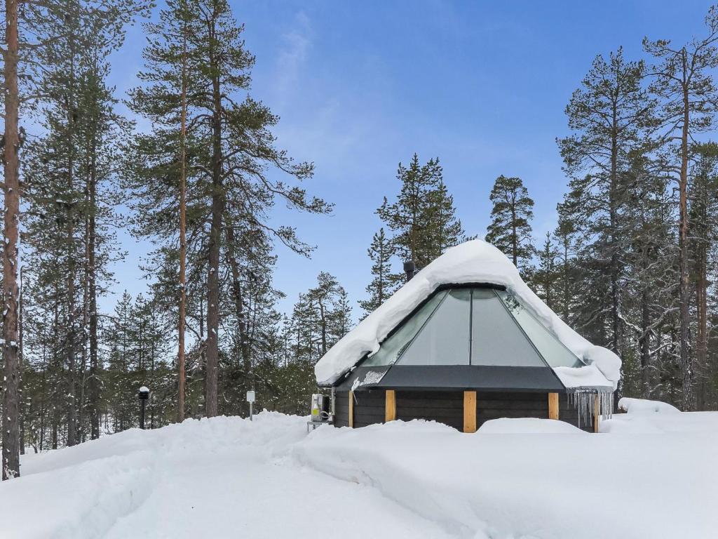 ein schneebedecktes Gebäude mit Bäumen im Hintergrund in der Unterkunft Holiday Home Arctic light hut by Interhome in Kakslauttanen