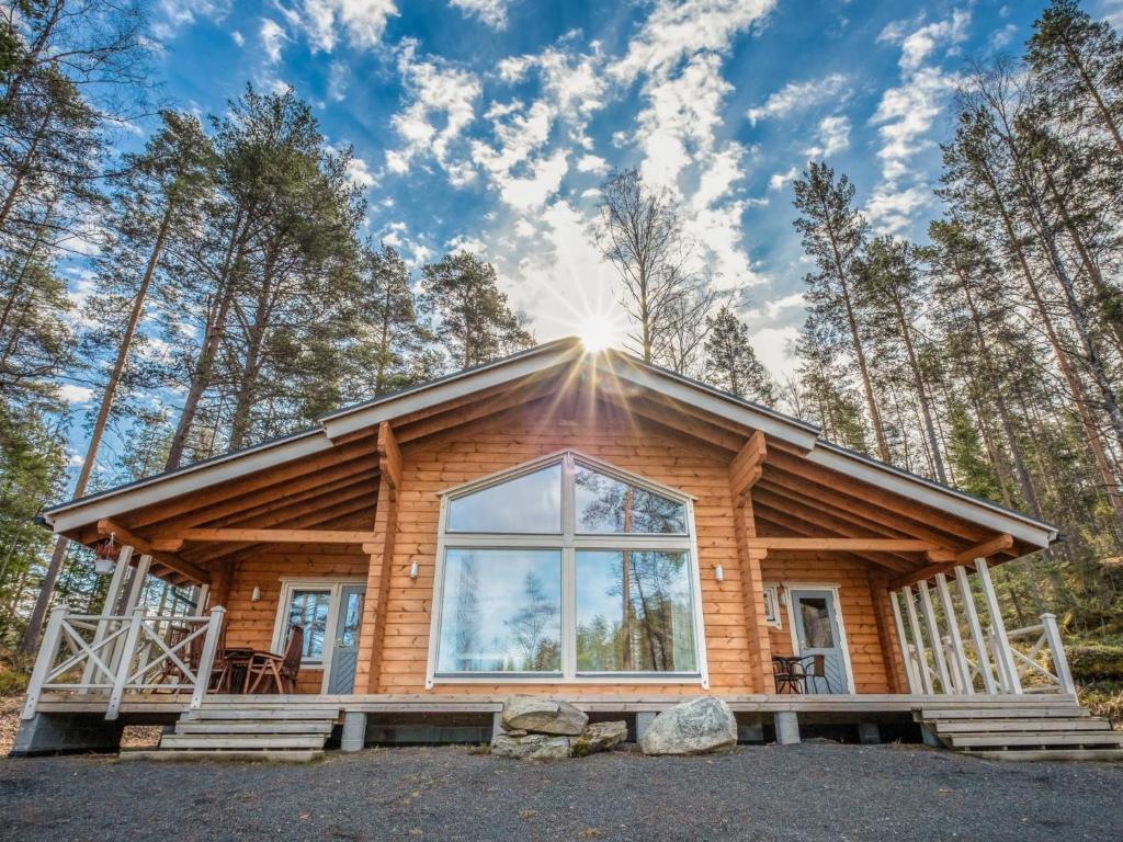 uma cabana de madeira na floresta com uma grande janela em Holiday Home Ritalahti by Interhome em Jäniskylä