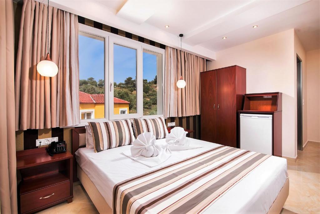 a bedroom with a bed and a large window at Hotel Diamond in Limenaria