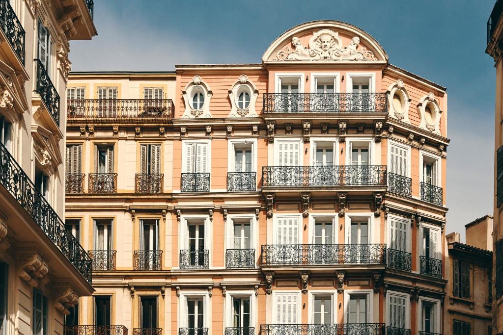 un grand bâtiment avec balcon dans une rue dans l'établissement Hôtel Saint Louis - Vieux Port, à Marseille