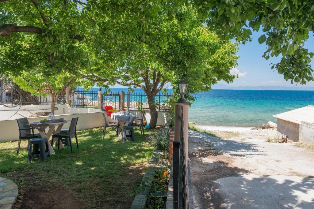 a view of the beach with tables and chairs at Ioanna Studios in Skala Kallirachis