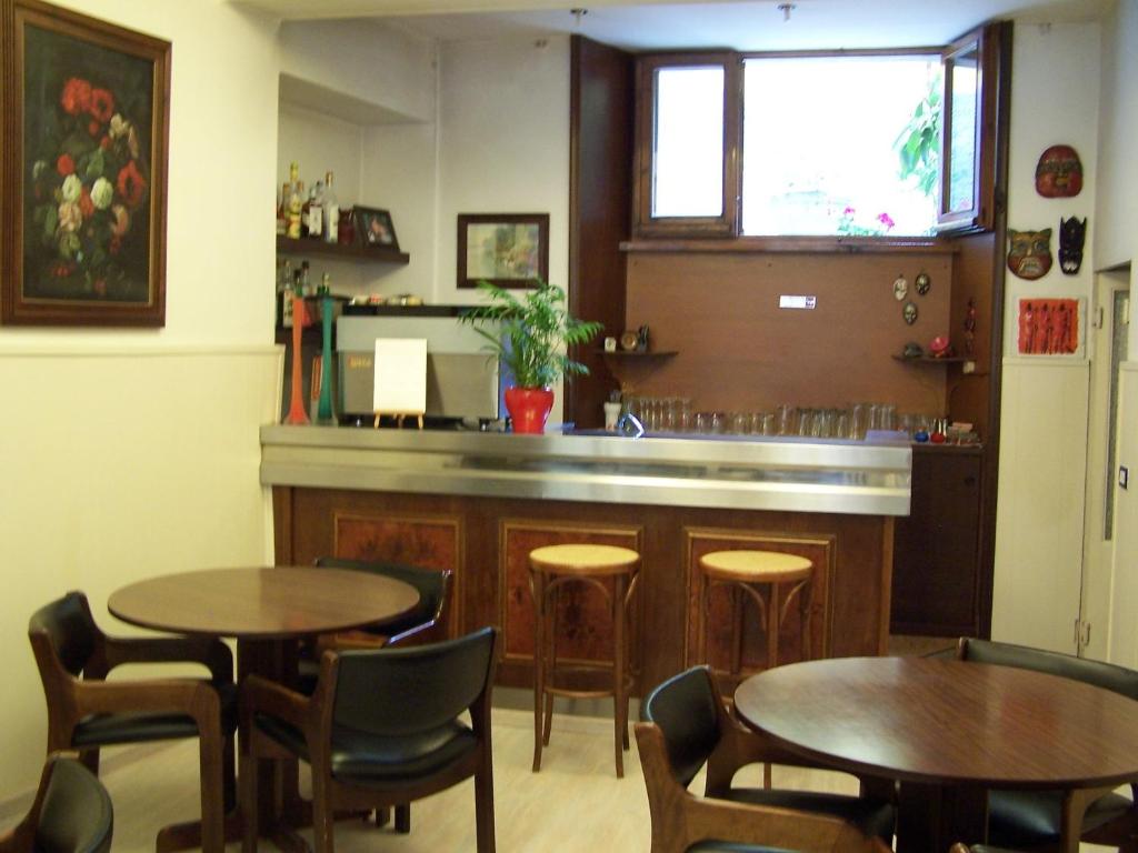 サルソマッジョーレ・テルメにあるAlbergo Coronaのテーブルと椅子2脚付きのレストラン、バー