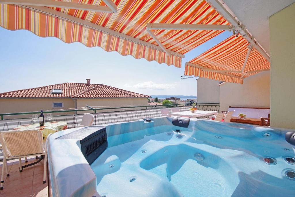 a hot tub on the balcony of a house at Apartments Ribarević in Makarska