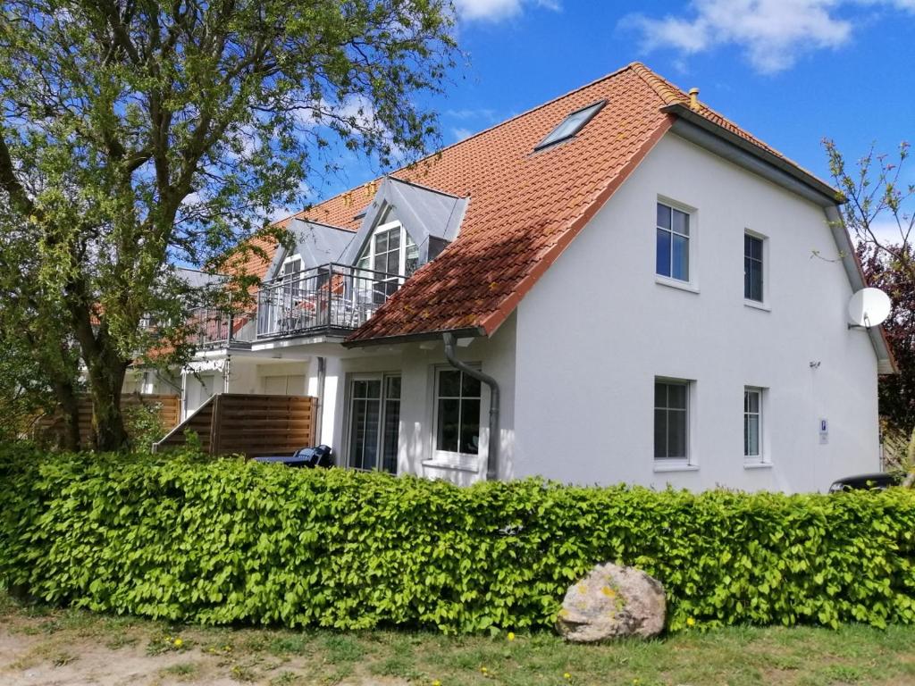 een wit huis met een rood dak bij Ferienwohnung Sonneneck in Insel Poel