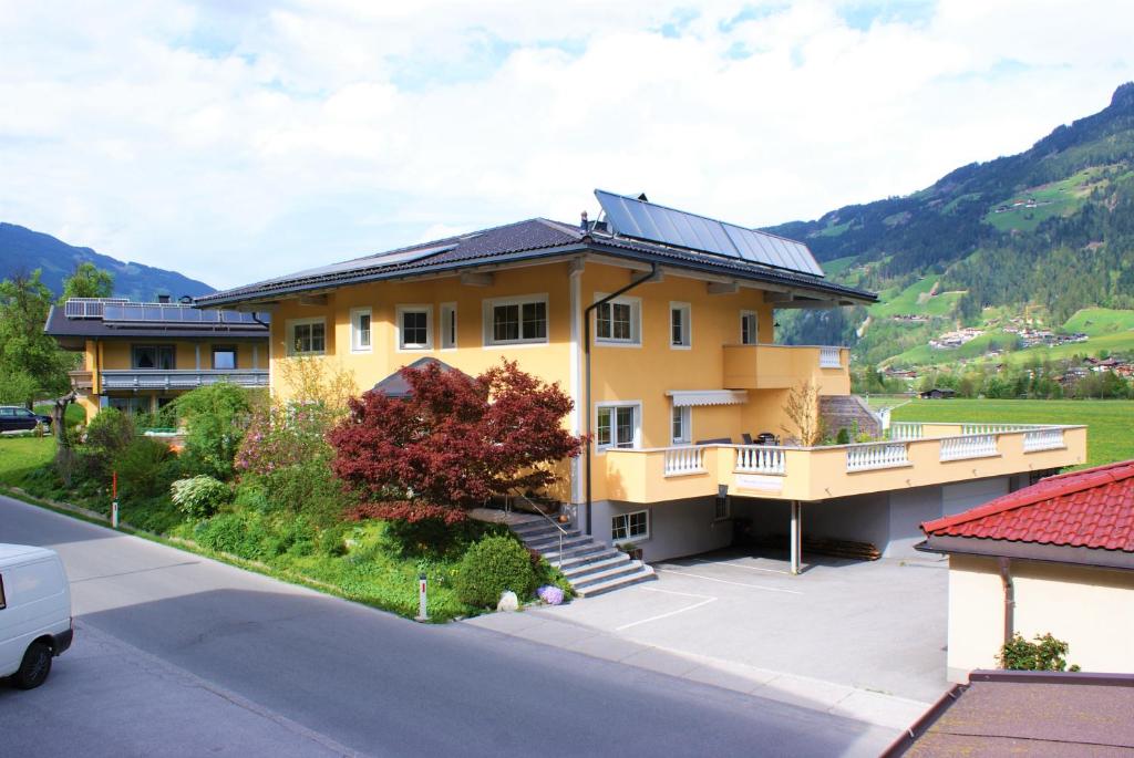 ein gelbes Haus mit einem Solarium darüber in der Unterkunft Traum-Ferienwohnungen Wechselberger Schwendau in Schwendau