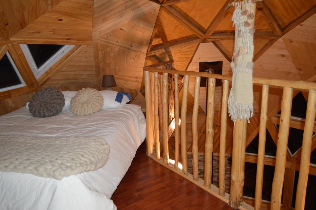 a room with a bed in a log cabin at domoschiloe in Ancud
