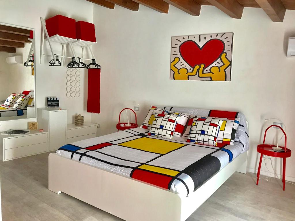 1 dormitorio con 1 cama y un corazón rojo en la pared en LaVallata87, en Ragusa