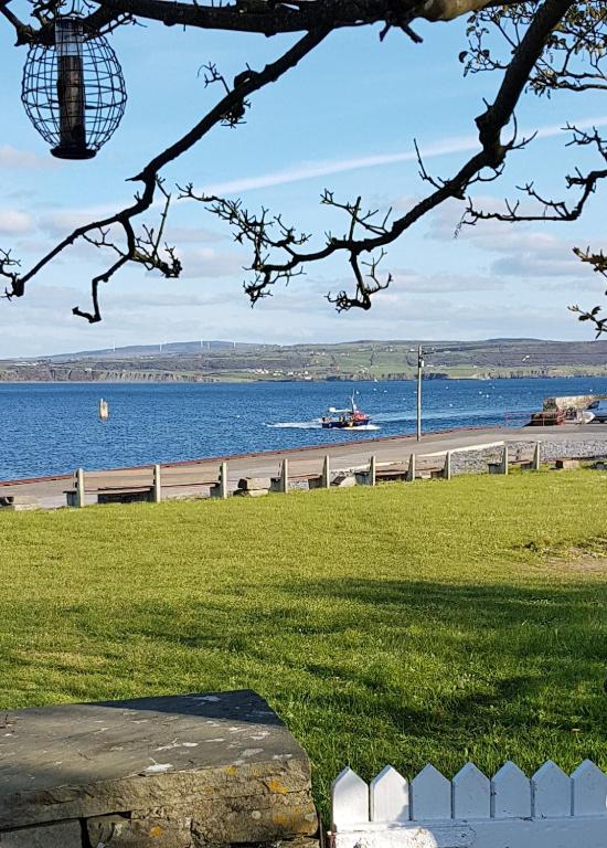 a view of a beach with a boat in the water at Bay View House in Liscannor