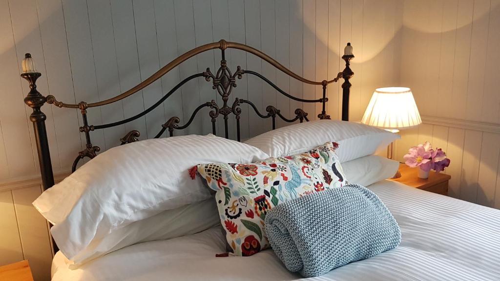 1 dormitorio con 1 cama con almohadas y lámpara en Bay View House, en Liscannor