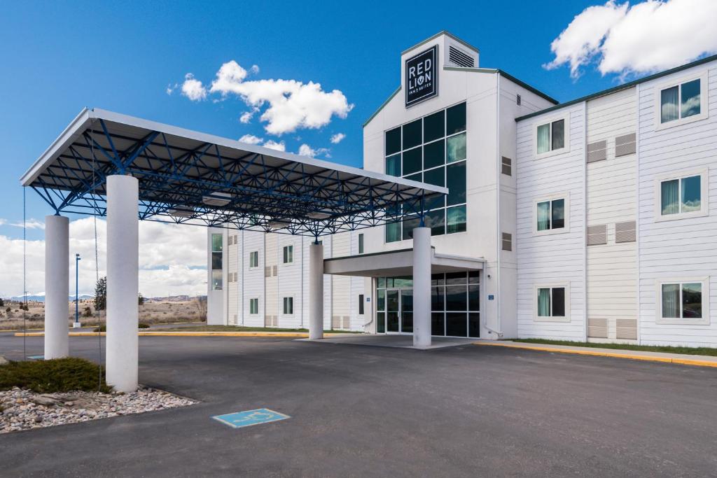 un grand bâtiment blanc avec un parking dans l'établissement Red Lion Inn & Suites Butte, à Butte