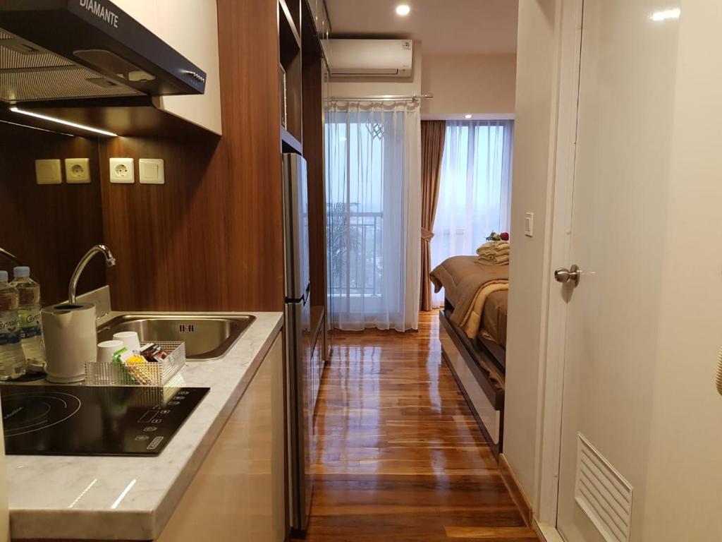 a kitchen with a sink and a bed in a room at M-Town Residence Gading Serpong by J`s Luxury Apartment in Tangerang