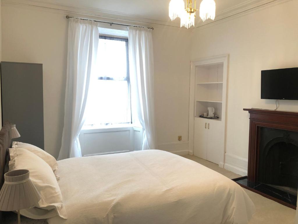 a white bedroom with a bed and a window at Arbroath Angus Lodge in Arbroath