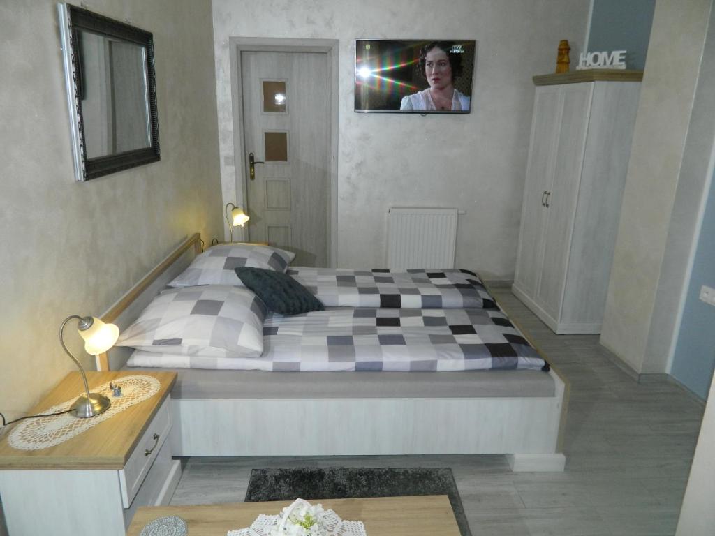 1 dormitorio con 1 cama grande y suelo a cuadros en Pokój gościnny ROYAL, en Świeradów-Zdrój