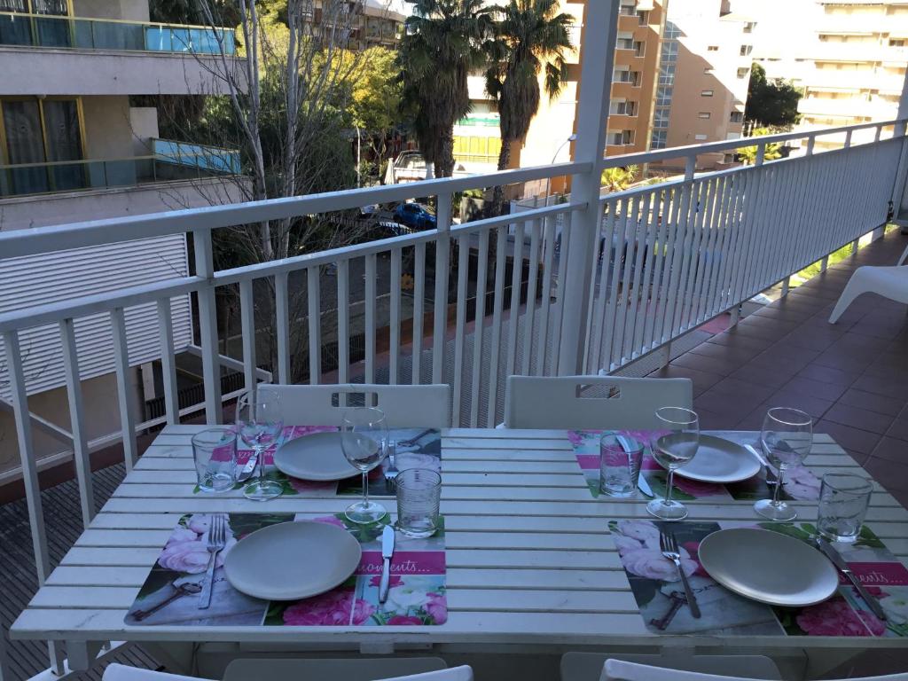 einen Tisch mit Tellern und Gläsern auf dem Balkon in der Unterkunft Flandria appartement 150m from beach in Salou